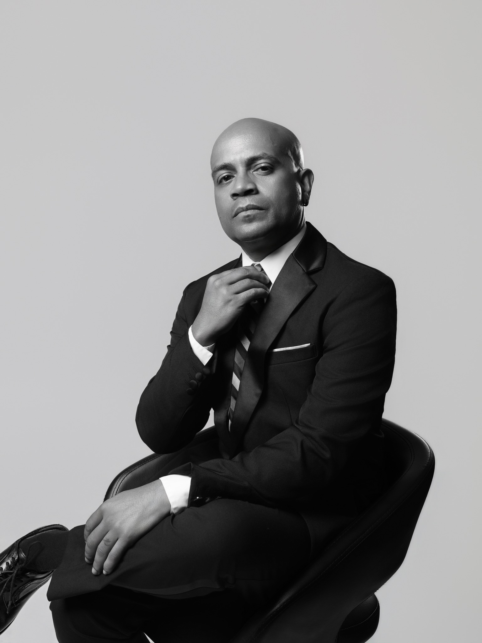 Black-and-white editorial suit portrait of Eric Velez